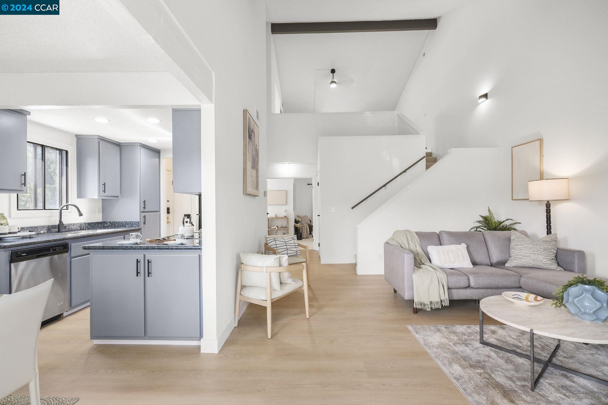 a living room with furniture and kitchen view