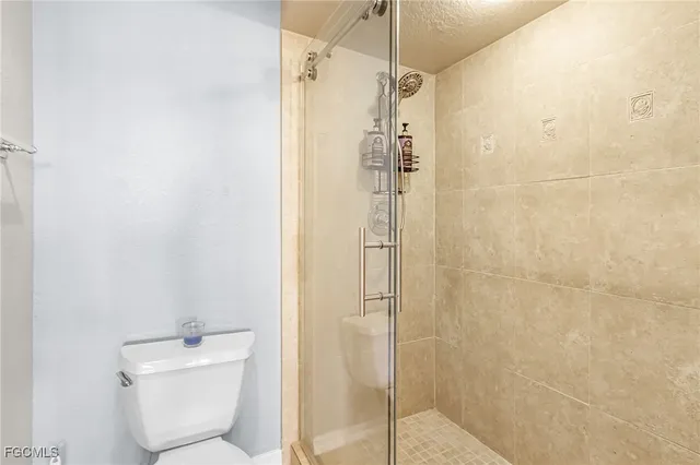 a bathroom with a shower a toilet and a sink