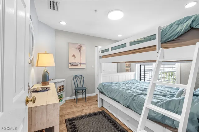 a bedroom with a bed and a table in it with wooden floor