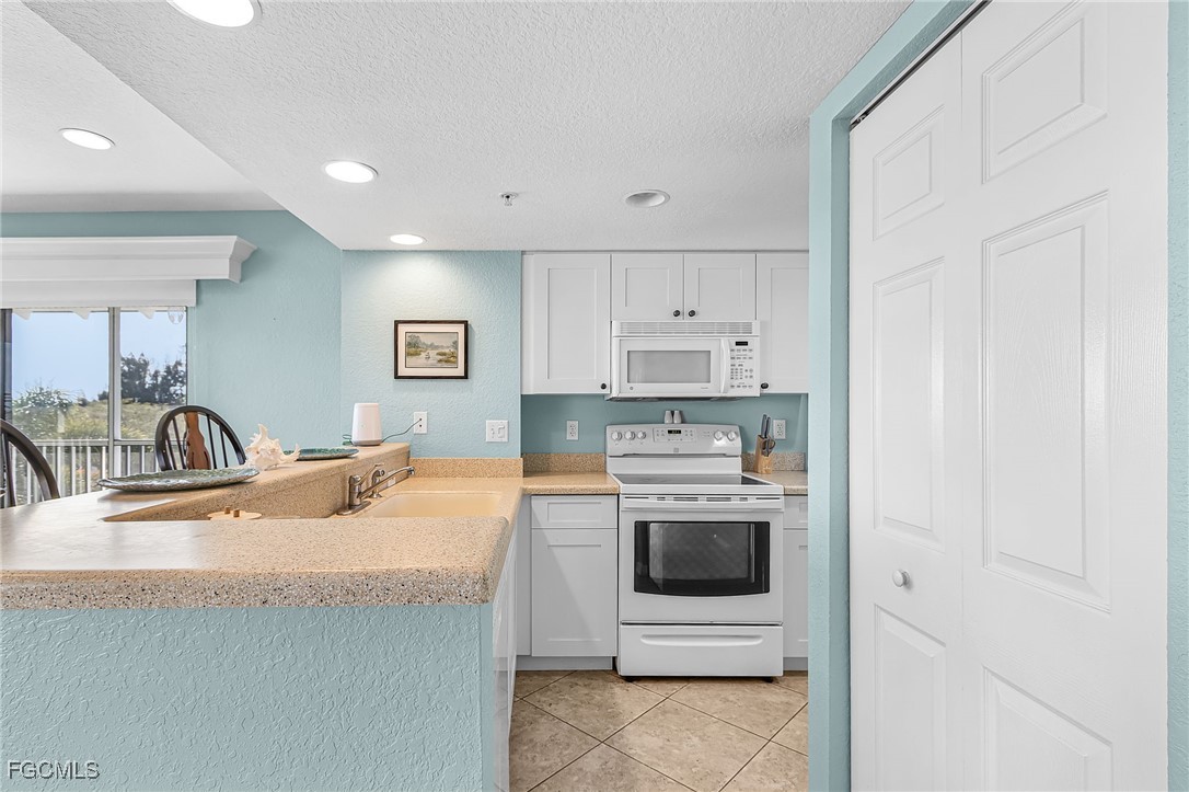 16641 Stringfellow Road, Unit 506 Bokeelia, FL 33922 - Photo 10 of 33 a kitchen with stainless steel appliances granite countertop a sink stove and refrigerator