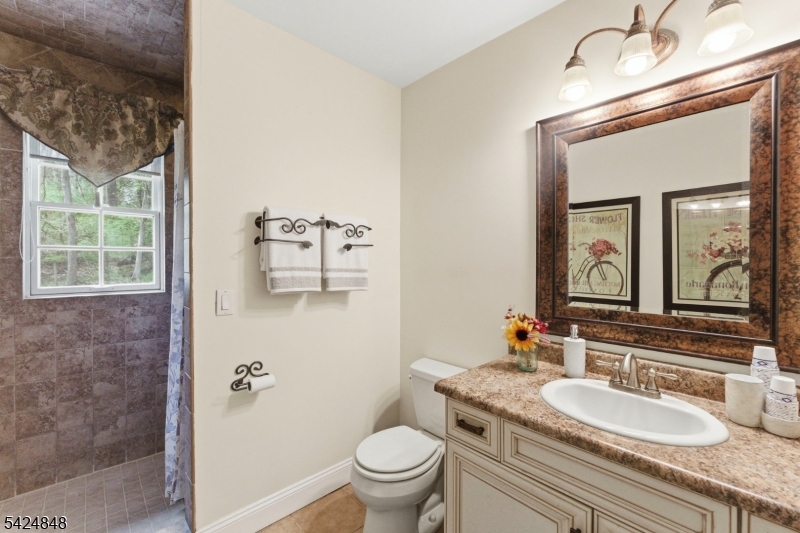 18 Valhalla Road Montville, NJ 07045 - Photo 21 of 33 a bathroom with a granite countertop toilet a sink and a mirror