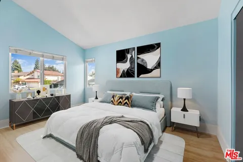 a bedroom with a bed and wooden floor