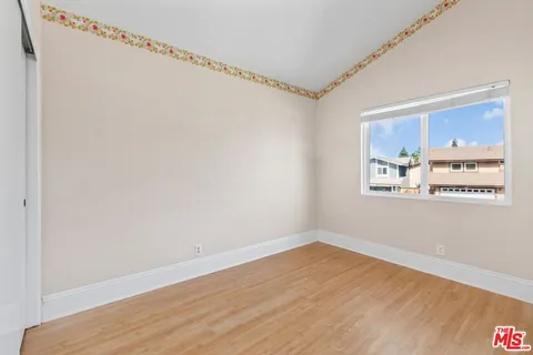 a view of a room with wooden floor and a window