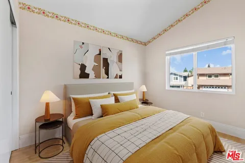 a bedroom with a bed and painting on the wall