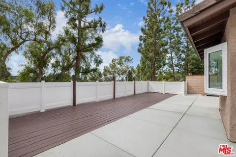 a view of backyard with table and chairs and potted plants