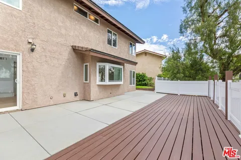 a view of back yard of the house with plants and trees