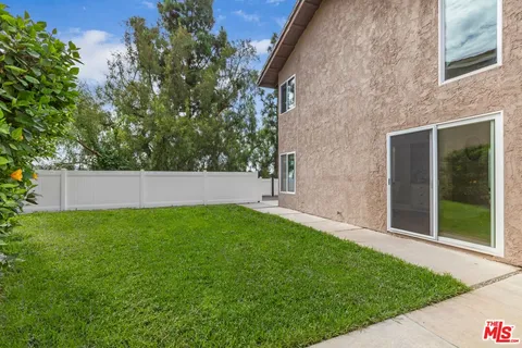 a view of a swimming pool with a bench and trees in the background