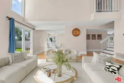 a living room with furniture flowerpot and a large window