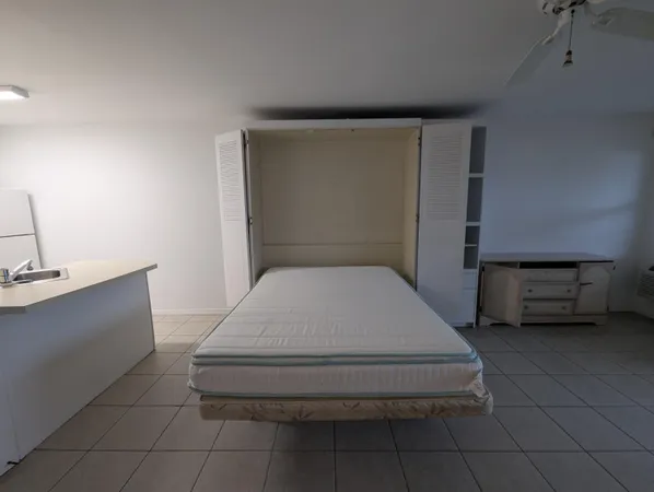 a bathroom with a granite countertop sink a toilet a mirror and shower