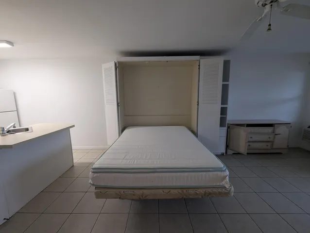 a bathroom with a granite countertop sink a toilet a mirror and shower