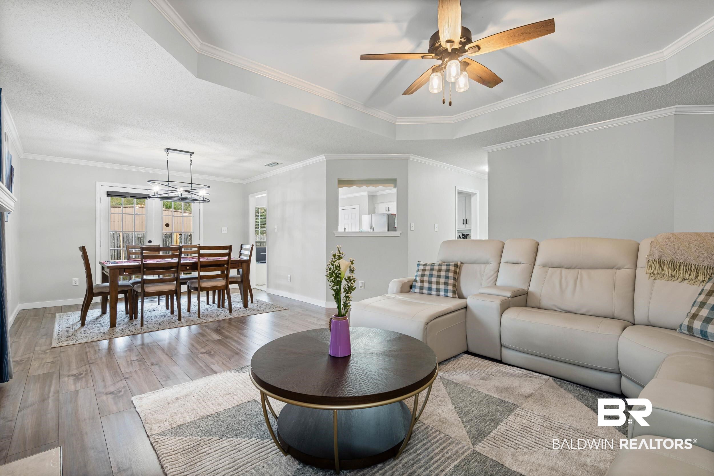 9590 Polo Pl Court Mobile, AL 36695 - Photo 4 of 22 Living area featuring ornamental molding, wood finished floors, a ceiling fan, and a tray ceiling