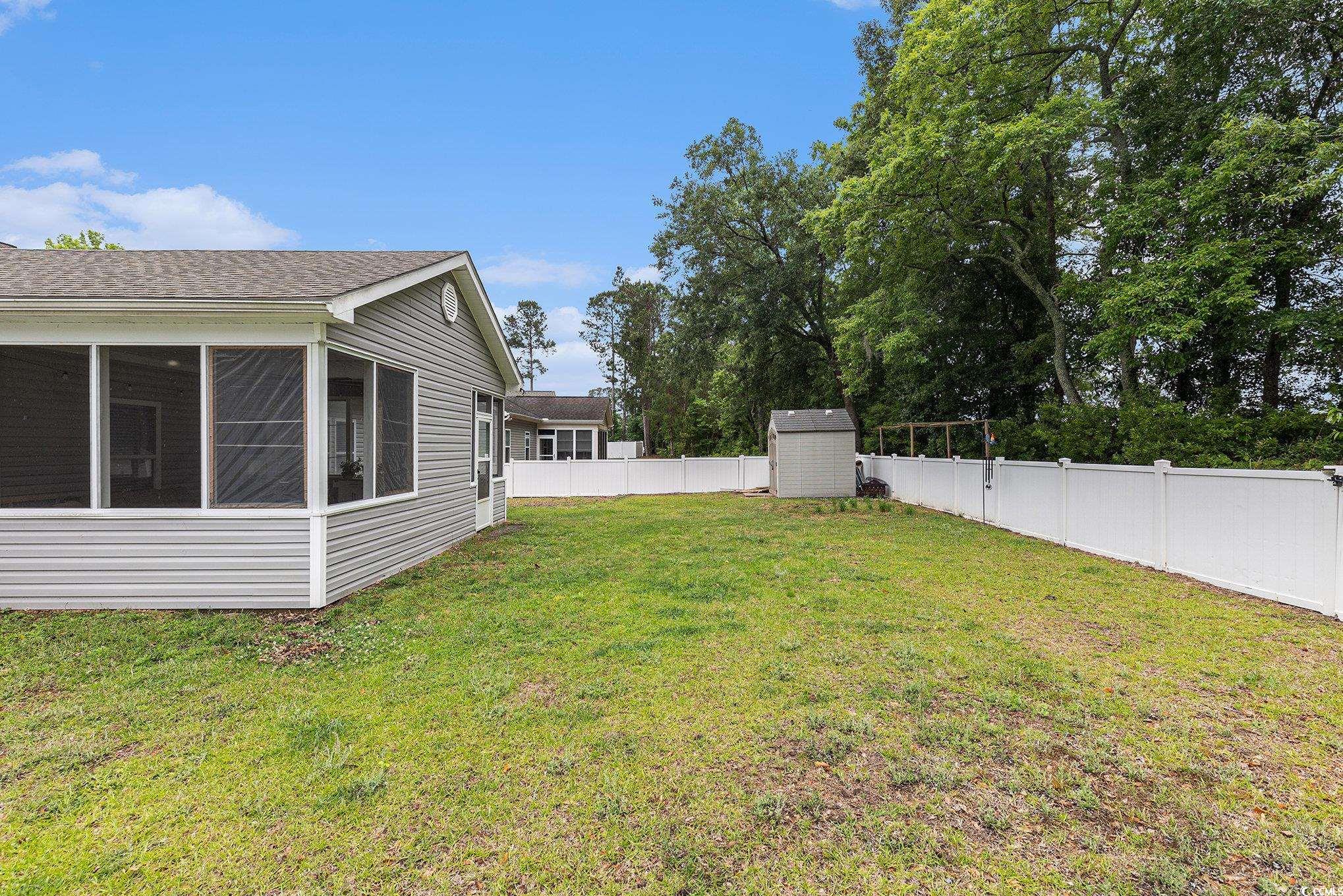 436 Cotton Grass Drive Loris, SC 29569 - Photo 26 of 33 View of yard featuring a sunroom, a shed, and an outbuilding