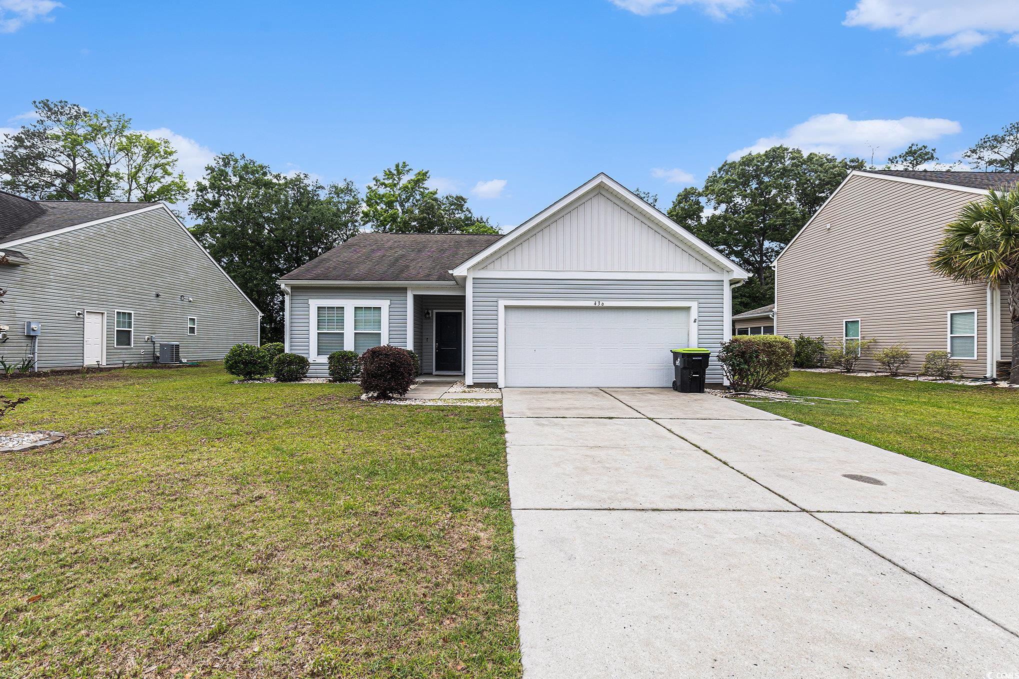436 Cotton Grass Drive Loris, SC 29569 - Photo 31 of 33 View of front of home featuring a garage, a front yard, driveway, and board and batten siding