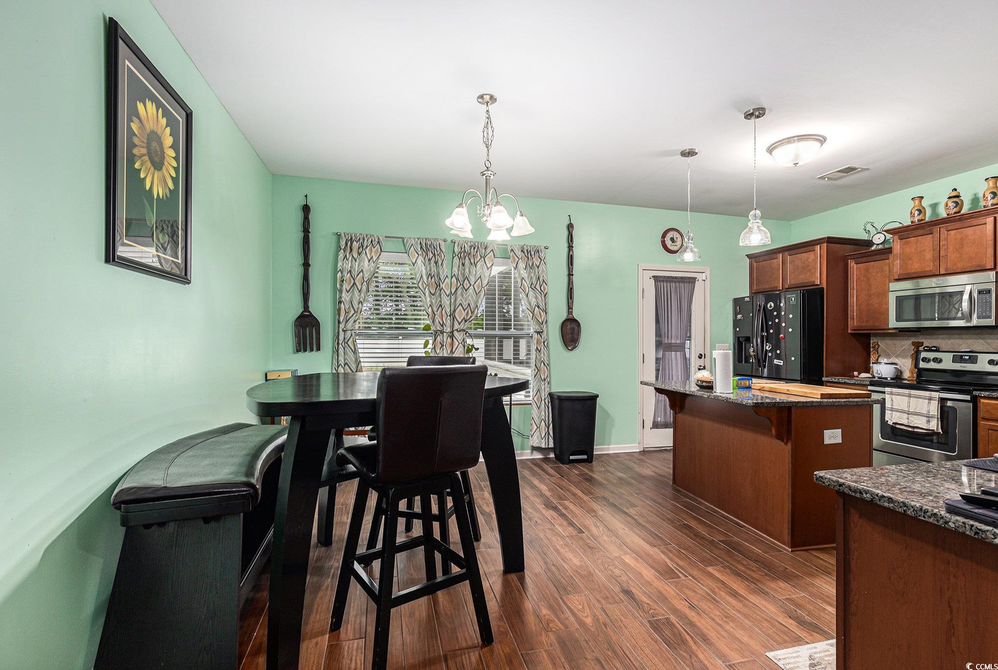 436 Cotton Grass Drive Loris, SC 29569 - Photo 10 of 33 Kitchen with appliances with stainless steel finishes, a chandelier, dark wood finished floors, a breakfast bar, and a kitchen island