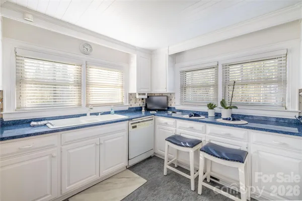a kitchen with stainless steel appliances granite countertop a sink a stove a counter space and cabinets