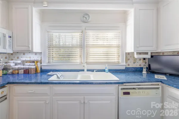 a kitchen with stainless steel appliances white cabinets stove a sink and dishwasher