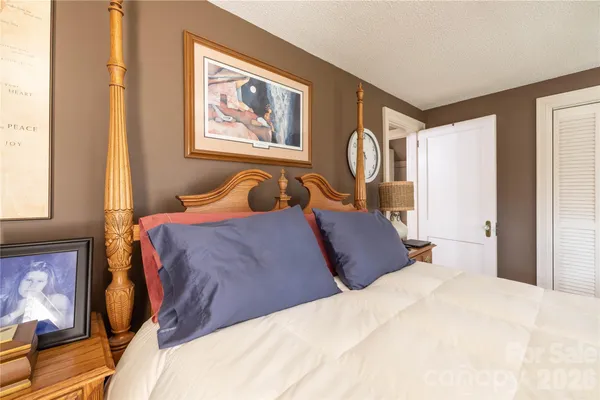 a bedroom with a large bed and a chandelier
