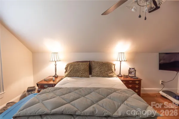 a bedroom with a bed and wooden floor