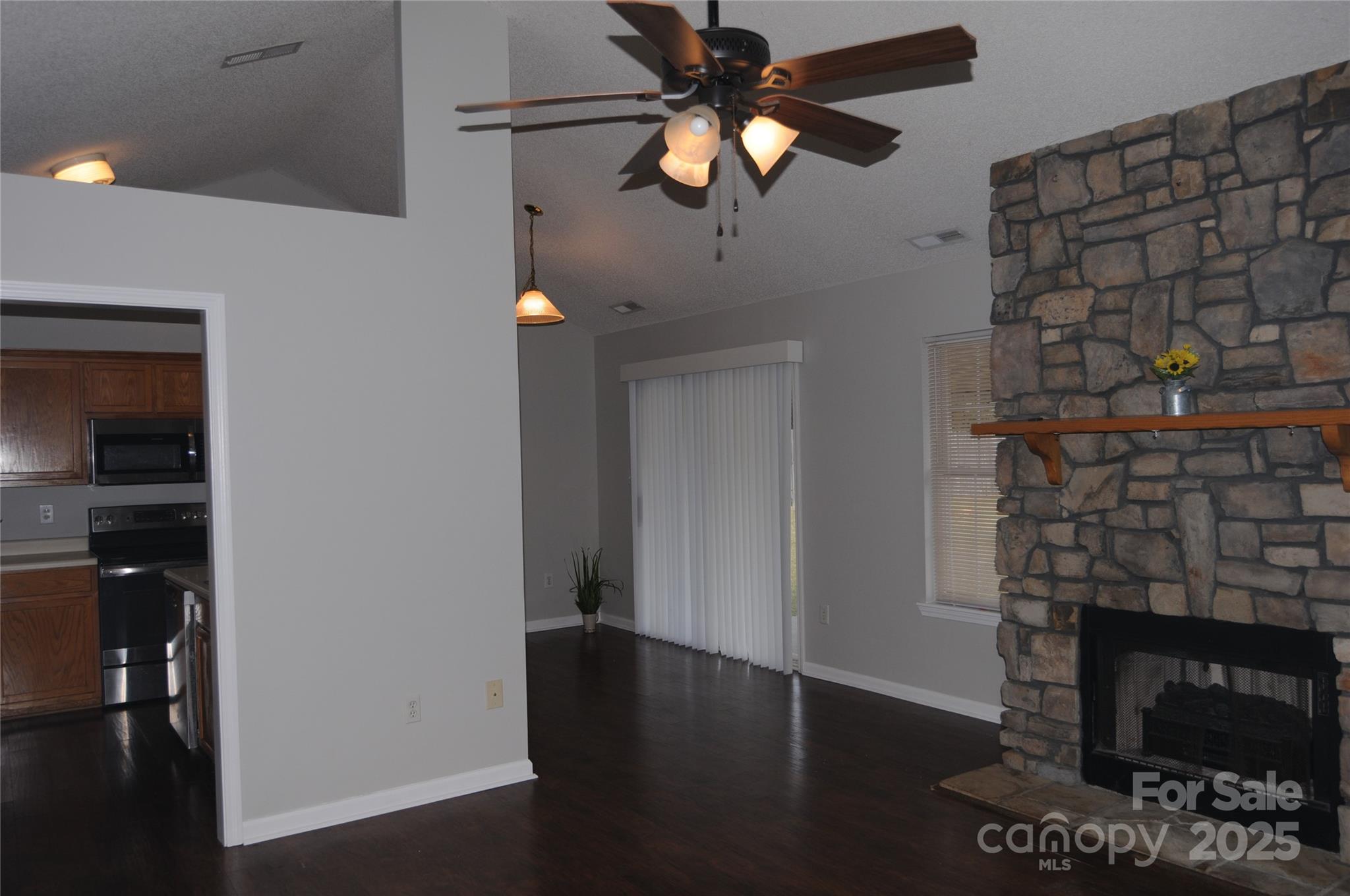 163 Planters Row Road Iron Station, NC 28080 - Photo 4 of 33 an empty room with a fireplace and wooden floor