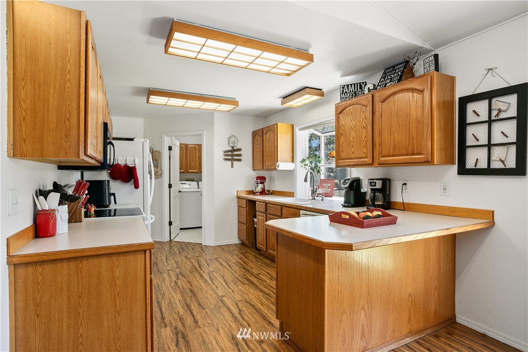 18926 Nutmeg Street Southwest Rochester, WA 98579 - Photo 11 of 23 a kitchen with stainless steel appliances granite countertop a sink dishwasher stove and refrigerator with wooden floor