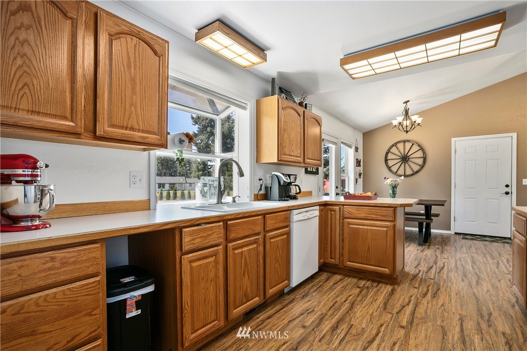 18926 Nutmeg Street Southwest Rochester, WA 98579 - Photo 10 of 23 a kitchen with stainless steel appliances granite countertop a sink dishwasher and cabinets with wooden floor