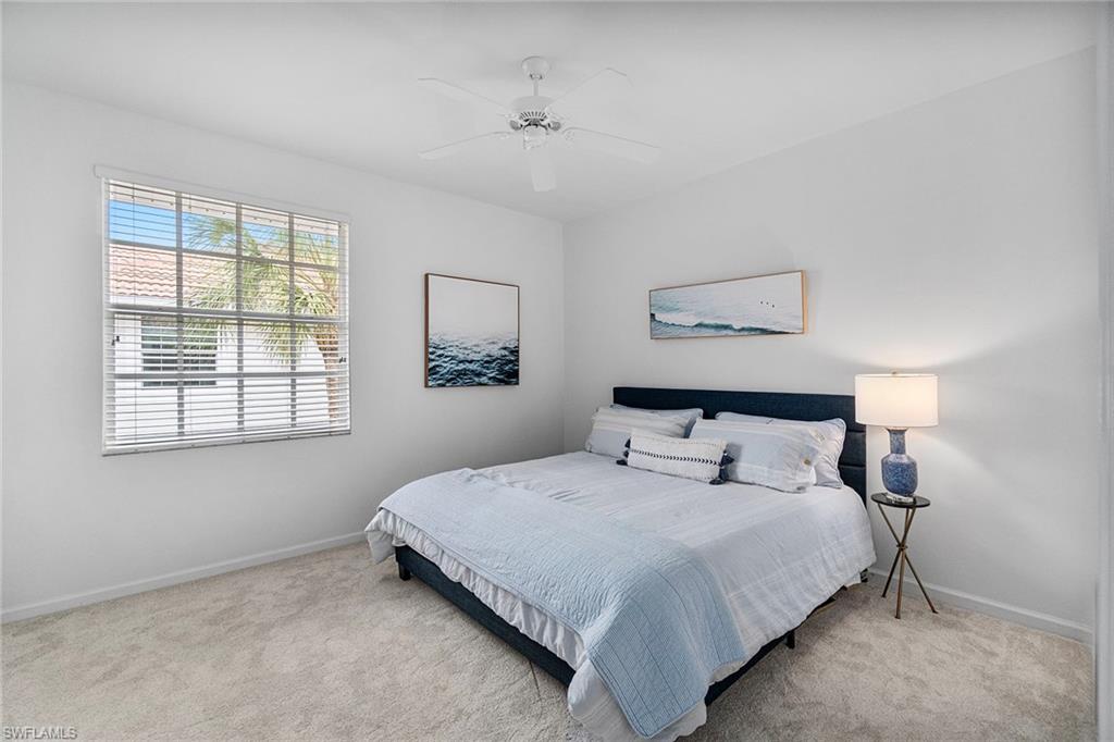23081 Rosedale Drive, Unit 201 Estero, FL 34135 - Photo 11 of 18 a bedroom with a bed and a night stand