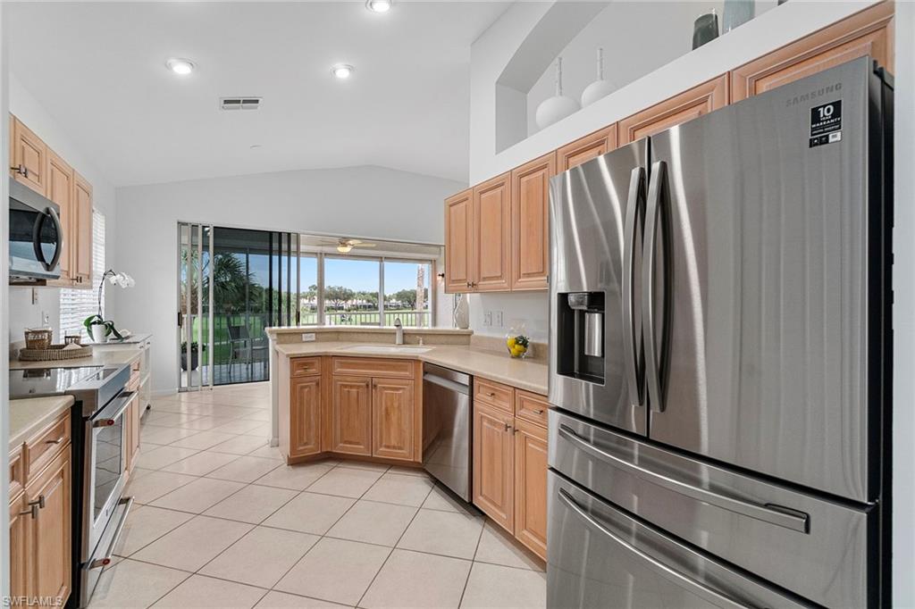 23081 Rosedale Drive, Unit 201 Estero, FL 34135 - Photo 5 of 18 a kitchen with stainless steel appliances a refrigerator sink and stove