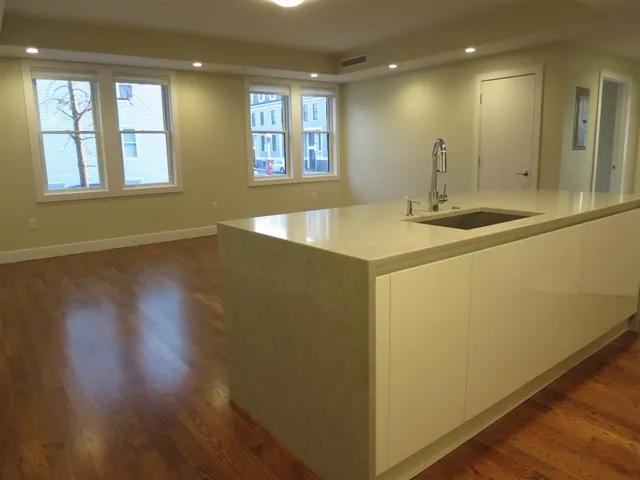 a view of a kitchen with a sink and wooden floor