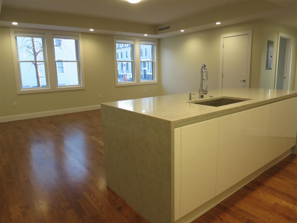 a view of a kitchen with a sink and wooden floor