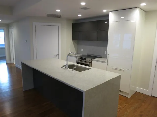 a kitchen with a sink cabinets and wooden floor