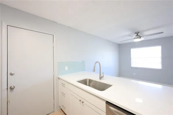 an empty room with a window and a fan