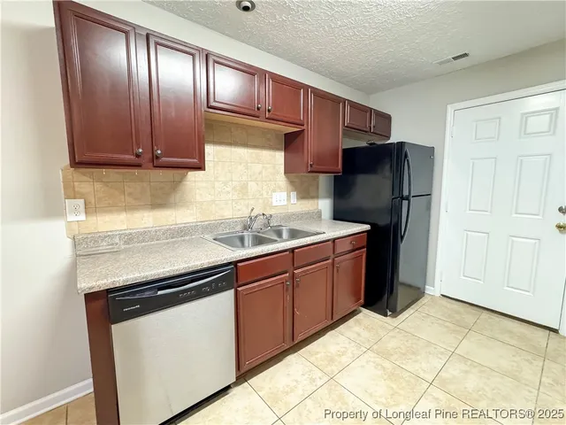 a kitchen with stainless steel appliances granite countertop a stove refrigerator and cabinets