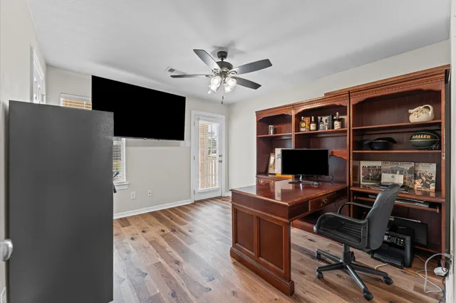 a view of a workspace with furniture and wooden floor