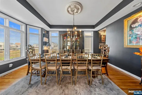 a view of a dining room with furniture a chandelier and wooden floor