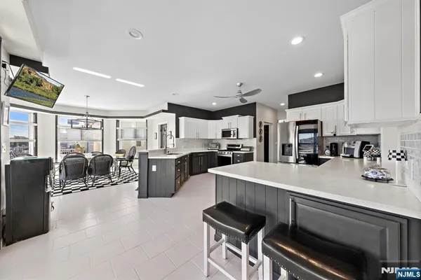 a large white kitchen with lots of counter space dining table and chairs