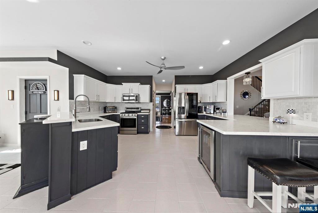 19 Maryland Road Little Egg Harbor, NJ 08087 - Photo 19 of 48 a kitchen with stainless steel appliances kitchen island granite countertop a refrigerator a sink dishwasher and a stove with wooden cabinets