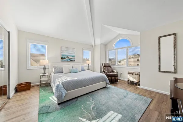 a spacious bedroom with a bed a table and large windows