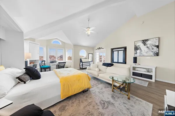 a bedroom with a bed a chair and painting on the wall
