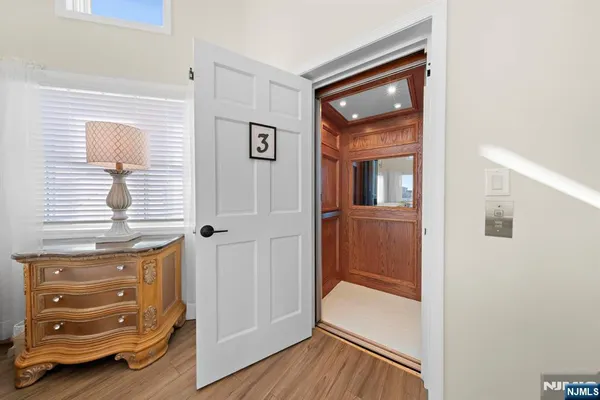 a view of a hallway with closet and wooden floor