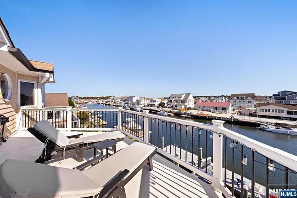 a view of a balcony with wooden floor and outdoor seating