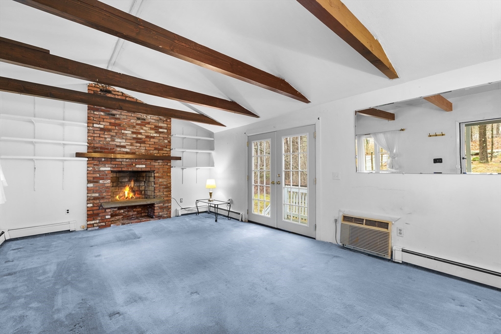 58 Lakeview Road Foxboro, MA 02035 - Photo 12 of 42 a view of an empty room with a fireplace and a window
