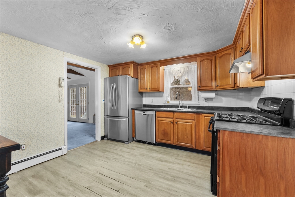 58 Lakeview Road Foxboro, MA 02035 - Photo 14 of 42 a kitchen with stainless steel appliances granite countertop a refrigerator a sink dishwasher a stove with large countertops and wooden floor