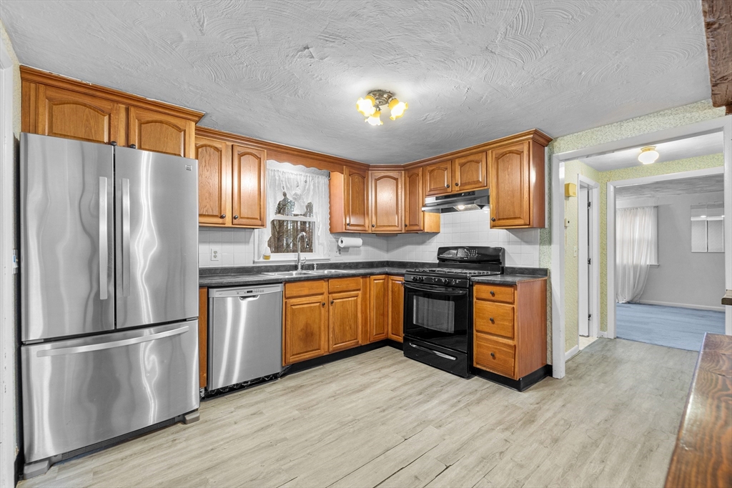 58 Lakeview Road Foxboro, MA 02035 - Photo 15 of 42 a kitchen with granite countertop stainless steel appliances a refrigerator cabinets and wooden floor