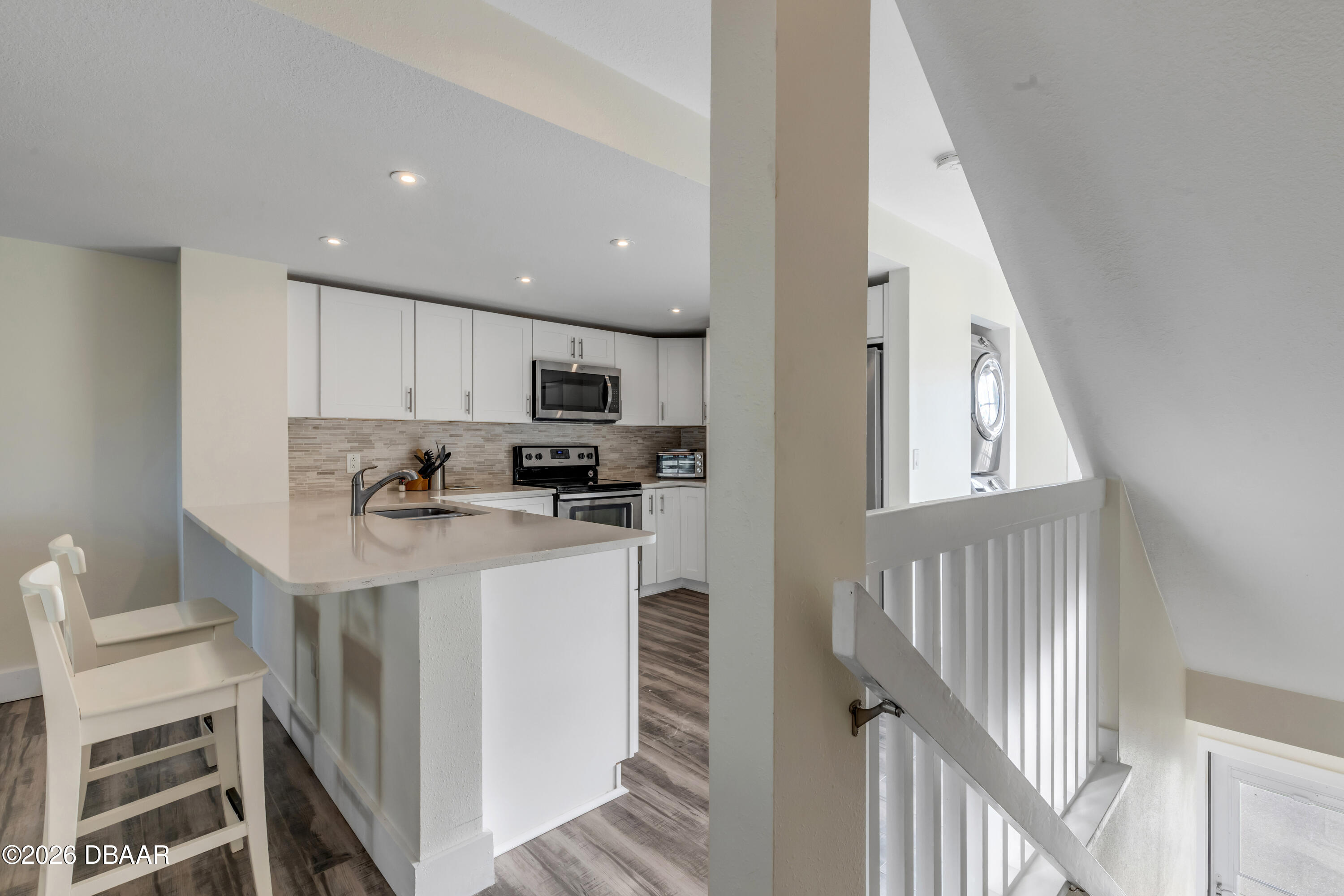 4752 South Atlantic Avenue, Unit 1 Ponce Inlet, FL 32127 - Photo 12 of 49 a kitchen with cabinets and wooden floor