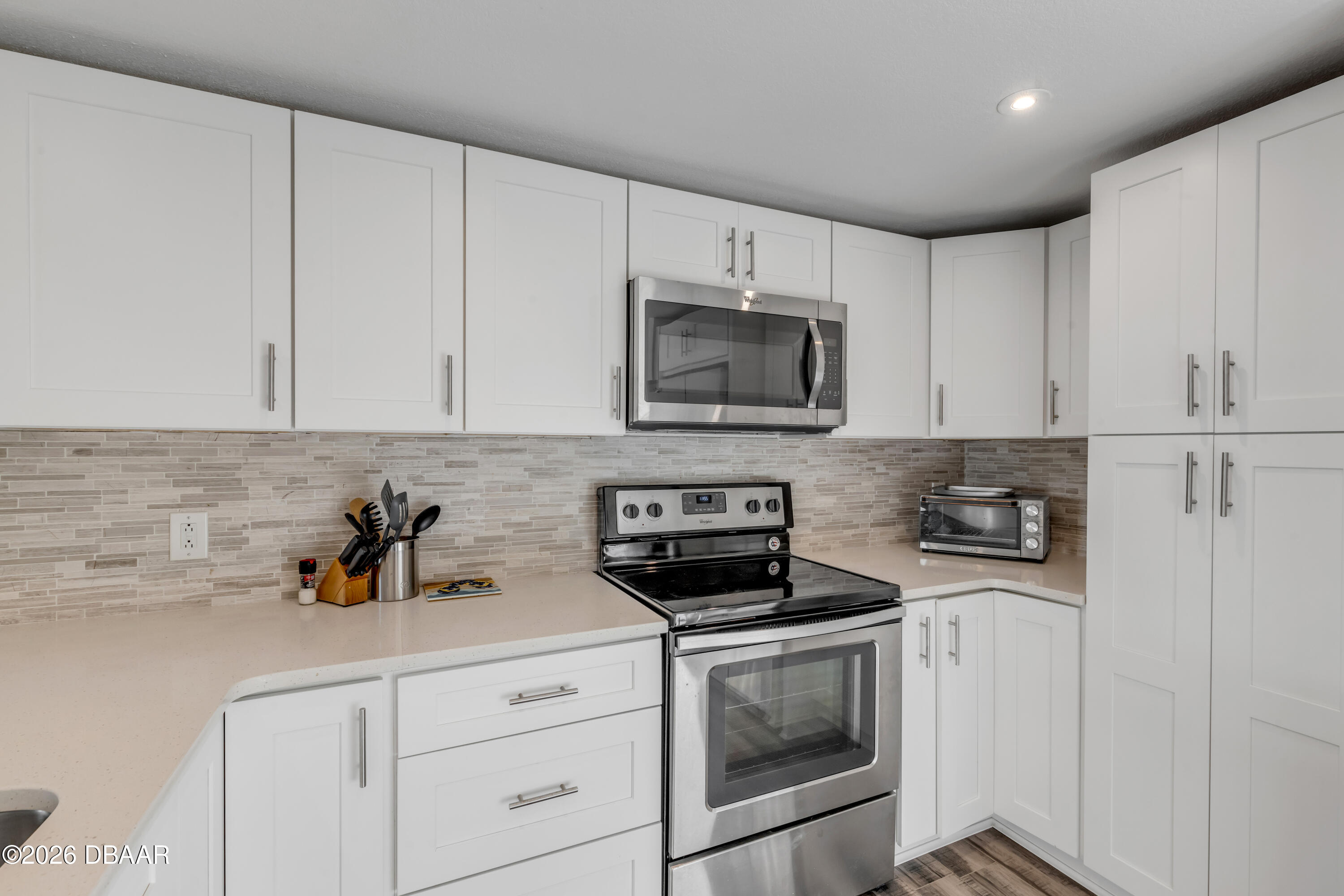 4752 South Atlantic Avenue, Unit 1 Ponce Inlet, FL 32127 - Photo 16 of 49 a kitchen with white cabinets stainless steel appliances and sink