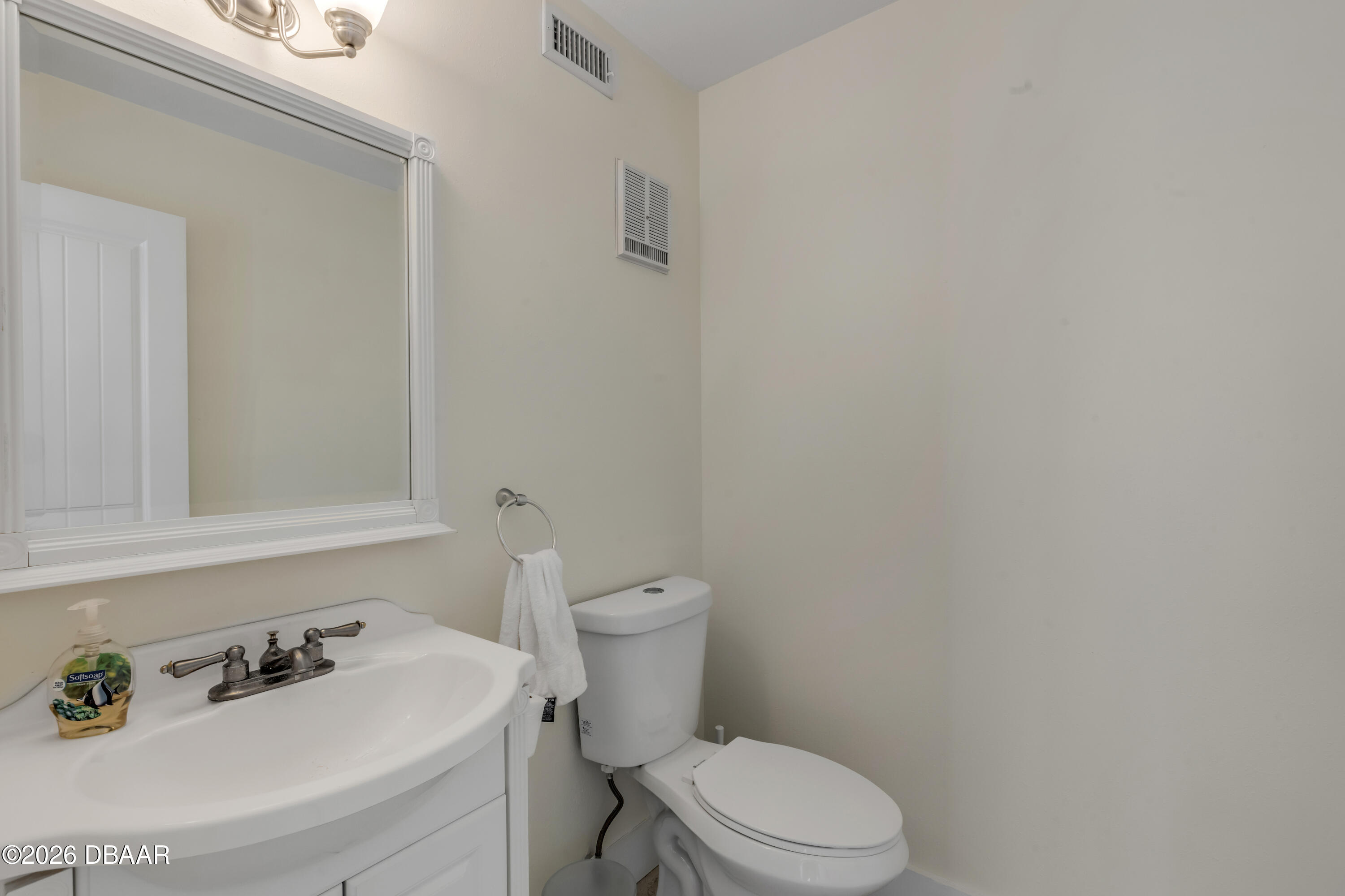 4752 South Atlantic Avenue, Unit 1 Ponce Inlet, FL 32127 - Photo 25 of 49 a white toilet sitting next to a bathroom sink
