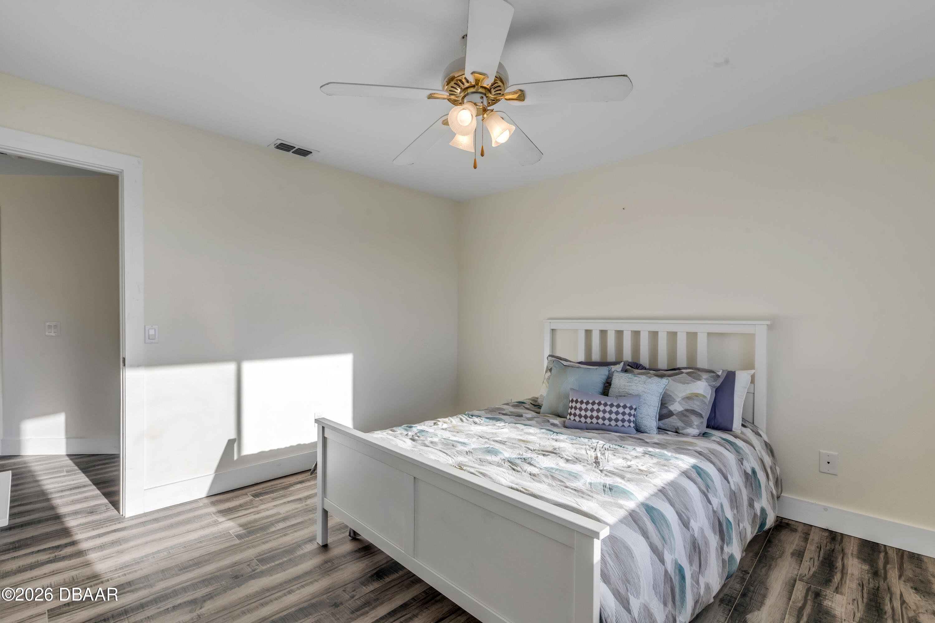 4752 South Atlantic Avenue, Unit 1 Ponce Inlet, FL 32127 - Photo 28 of 49 a bedroom with a bed and a chandelier