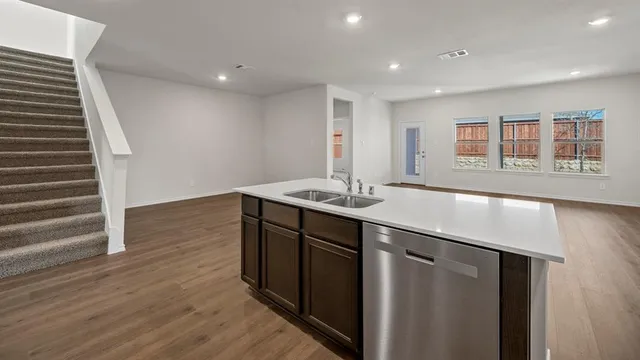 a kitchen with stainless steel appliances a sink stove top oven and wooden cabinets