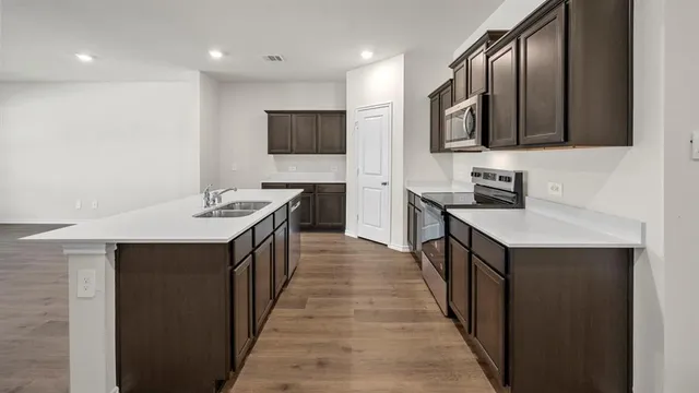 a kitchen with kitchen island a sink appliances and cabinets