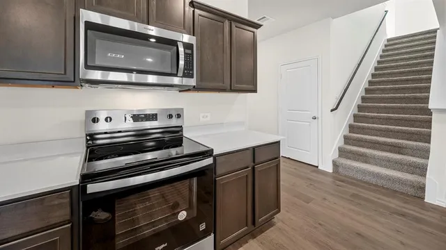 a large kitchen with stainless steel appliances granite countertop a sink and a stove top oven